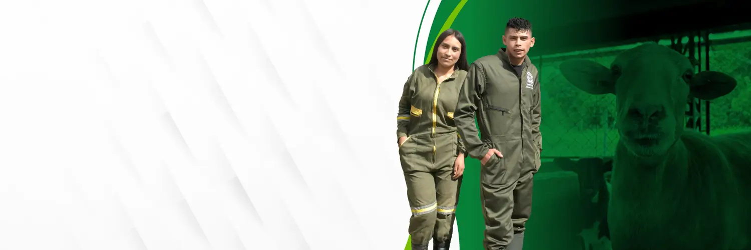 Dos jóvenes con overoles de trabajo posan junto a una oveja en un entorno rural