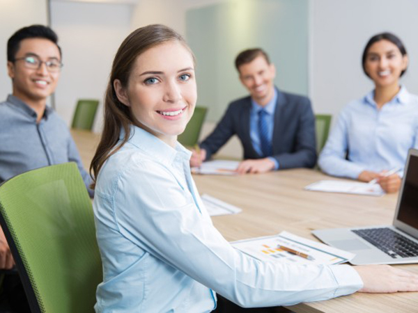 empresaria joven sonriente sentado en la sala de juntas