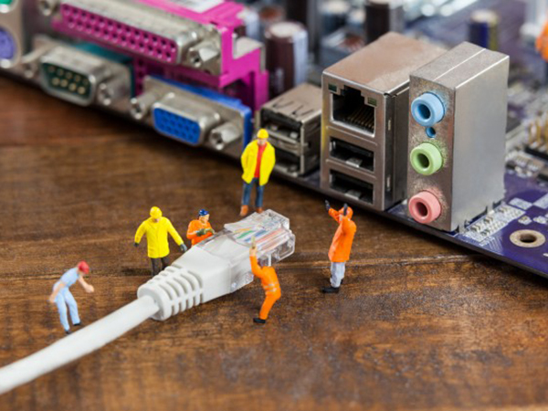 ingeniero en miniatura y el trabajador plug in de lan por cable a la computadora