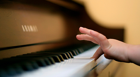 mano de niño tocando tecla de piano