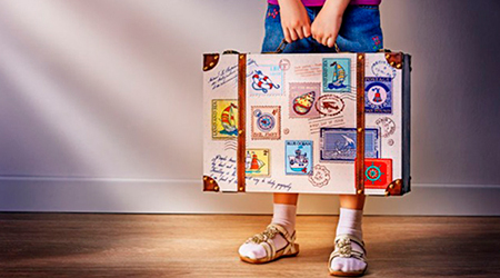 niño sosteniendo maleta de viaje